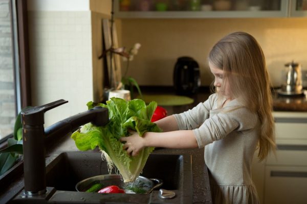 Little-girl-washes-vegetables